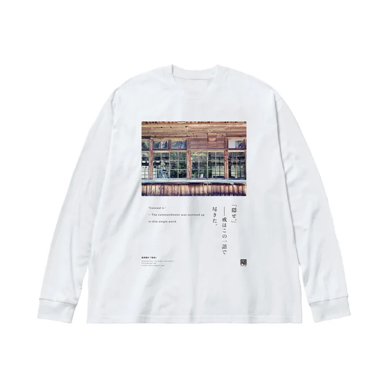 白い長袖Tシャツ。胸に「隠せ。」――戒はこの一語で尽きた。の一節と、飯田の木造校舎の実写を組んだグラフィック